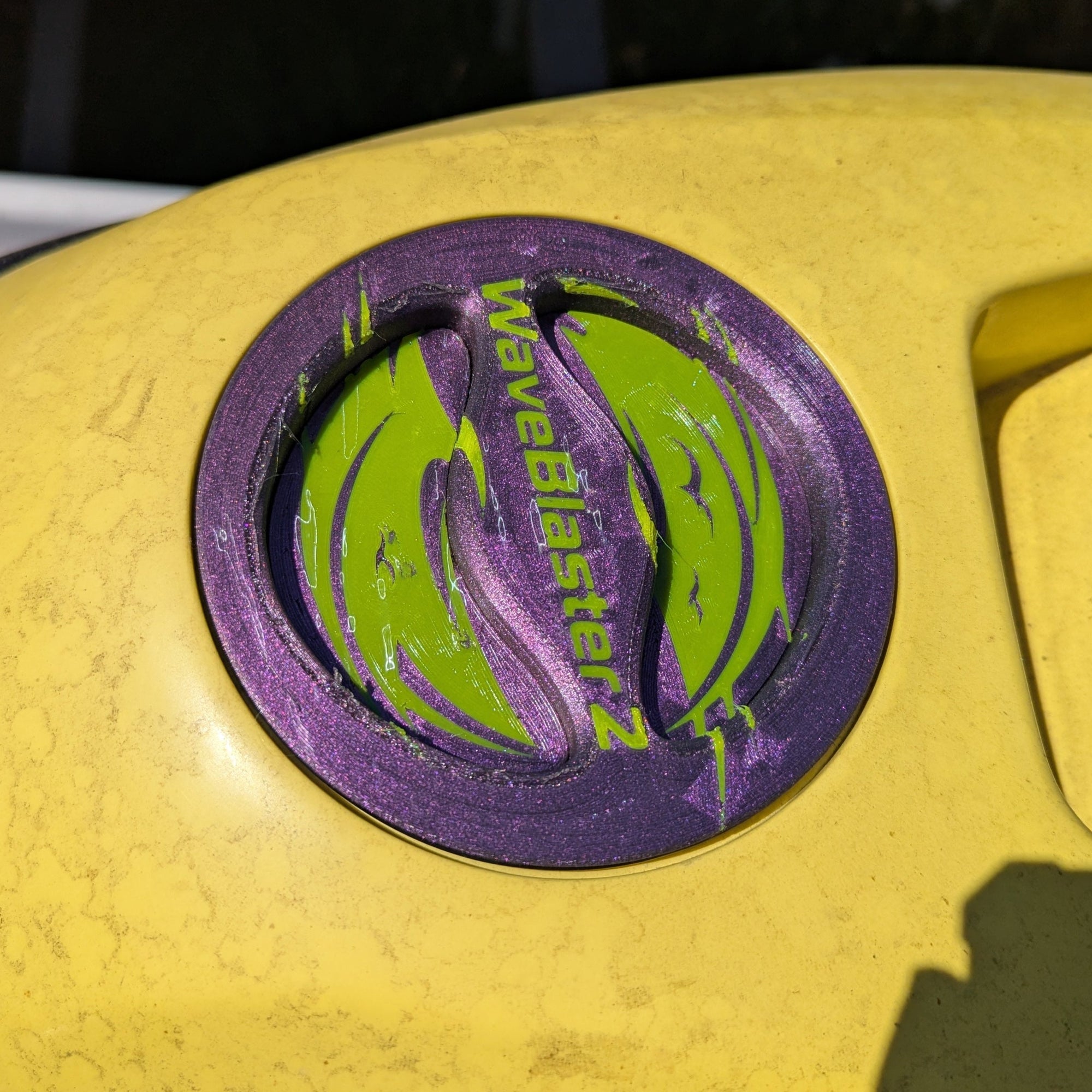 Close-up of a yellow Wave Blaster 2 Lid with a purple Made by Quenchifying